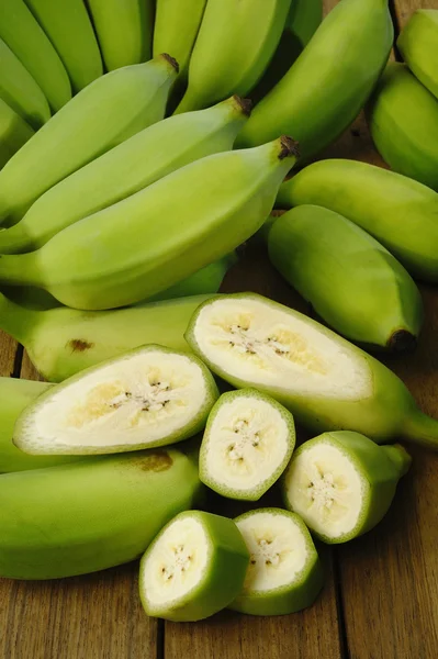 Bananas verdes em fundo de madeira — Fotografia de Stock