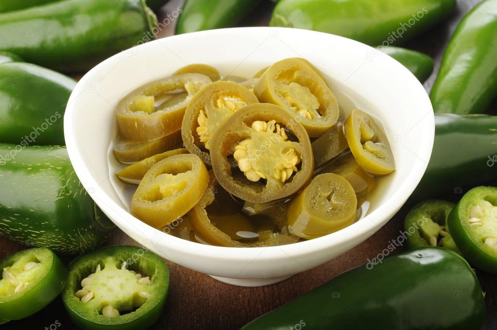  pickled sliced green jalapeno peppers in white bowl