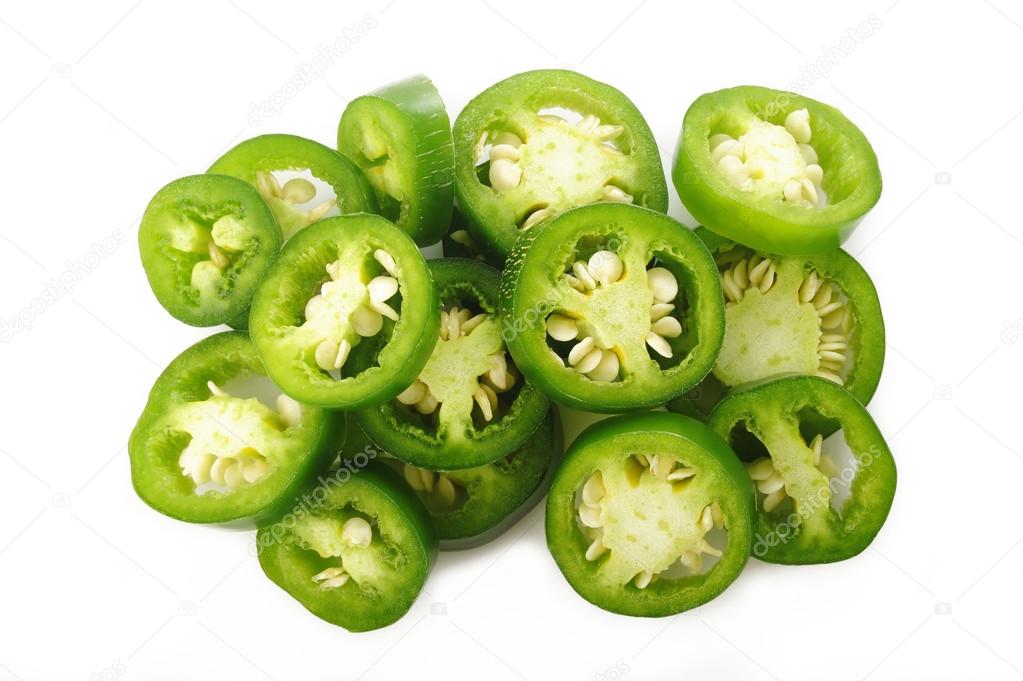 sliced green jalapeno peppers on white background
