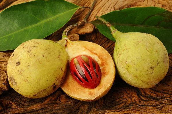 Muškátový oříšek ovoce na dřevěné pozadí — Stock fotografie
