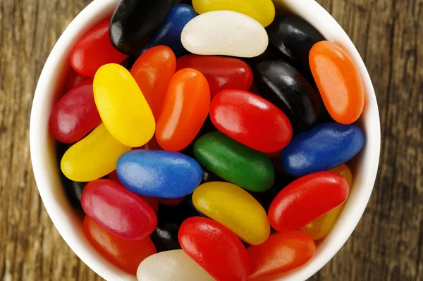 Jelly Beans in a bowl on wooden background — Stock Photo, Image