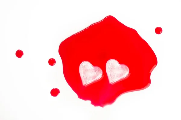 Cubos de gelo em forma de coração em suco vermelho — Fotografia de Stock