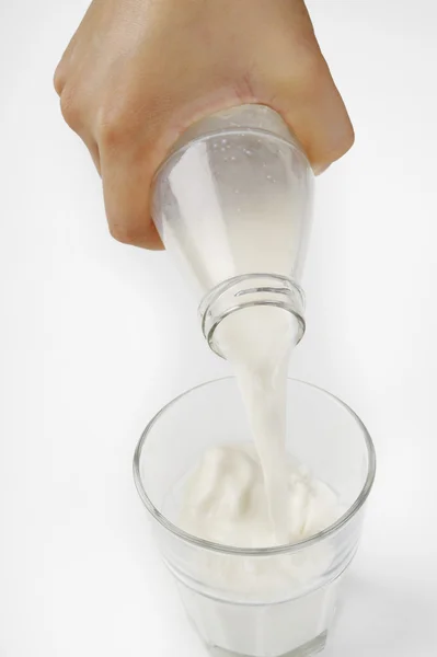 Hand gieten van melk van fles — Stockfoto