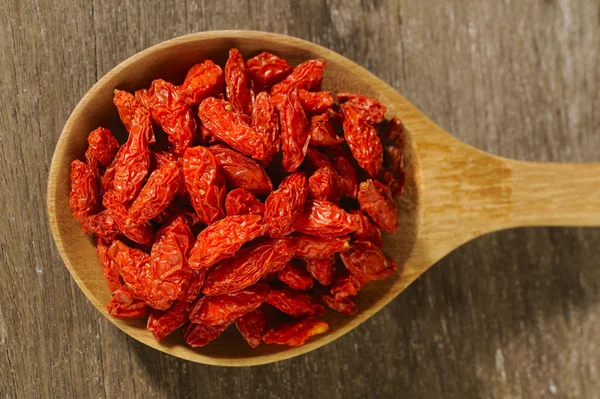 Bayas de goji secas rojas en cuchara de madera —  Fotos de Stock