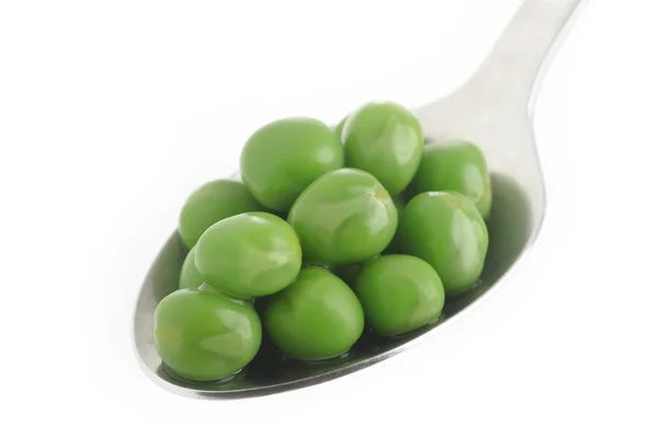 Cooked green peas in spoon — Stock Photo, Image