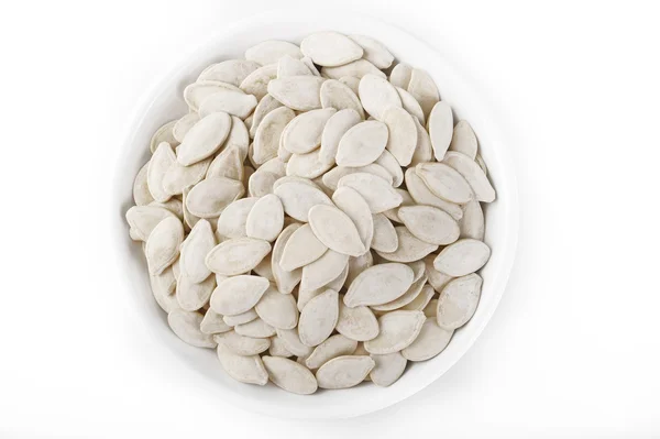 Shell of pumpkin seeds on white dish — Stock Photo, Image