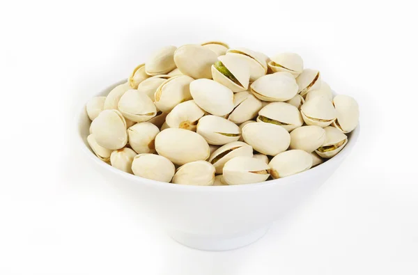 Pistachio nuts in a bowl on white background — Stock Photo, Image