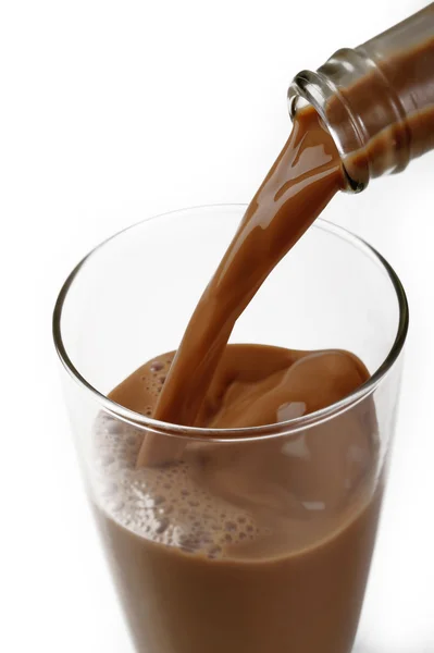 Versando latte al cioccolato dalla bottiglia — Foto Stock