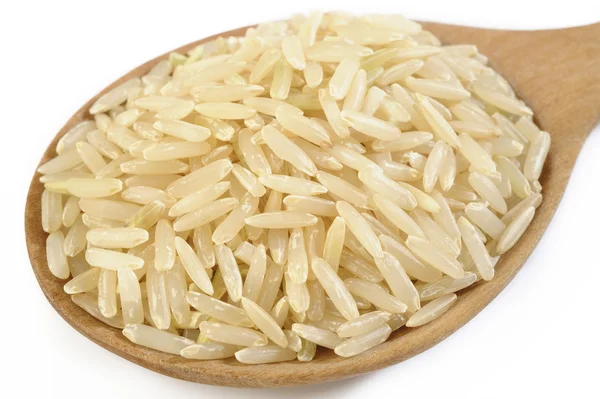 Коричневый рис в деревянной ложке — стоковое фото