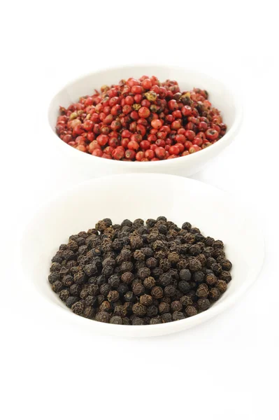 Rode peperkorrels zaden en zwarte peper — Stockfoto