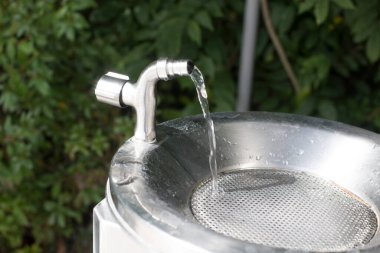 Park arka planında su musluğu açmak