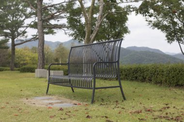 Yeşil çimlerde metal bank, parkta boş bank