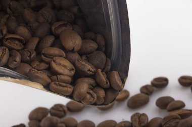 Kahve poşeti ve beyaz arka planda kahve çekirdeği.