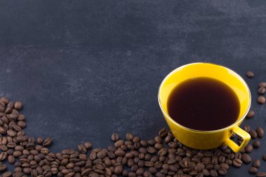 Sarı fincanda kahve ve kahve çekirdekleri izole