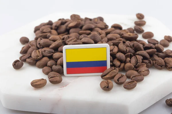 a Colombian flag placed over roasted coffee beans