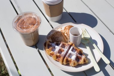 Kahve ve kruvasan waffle 'ı masaya koyun.