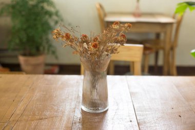 Kafe iç dekorasyonu, kırsal ahşap masa üzerindeki vazoda bir buket..