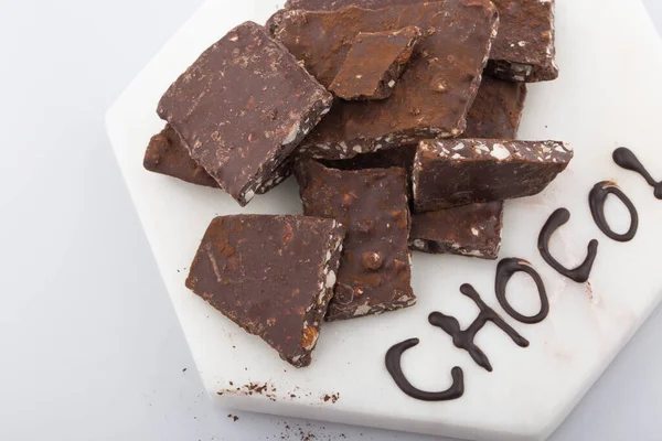 Gebroken of gebarsten stukjes chocolade geïsoleerd op witte achtergrond. — Stockfoto