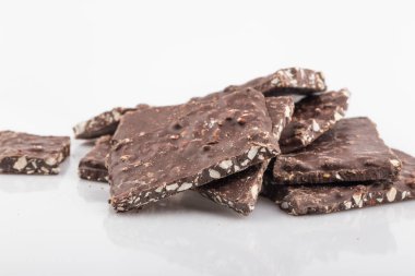 Kırık çikolata parçacıkları beyaz arka planda izole edilmiş.