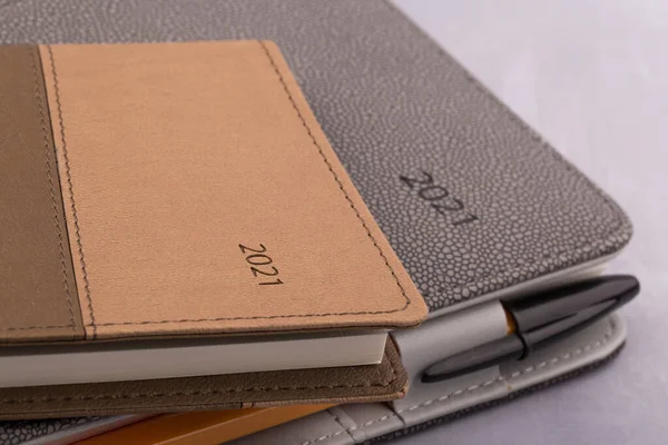 Gri zemin üzerine 2021 takvim defteri ve kalem