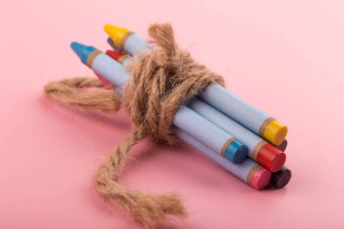 Pembe arka planda kısa renkli kalemler