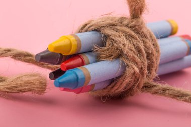 Pembe arka planda kısa renkli kalemler