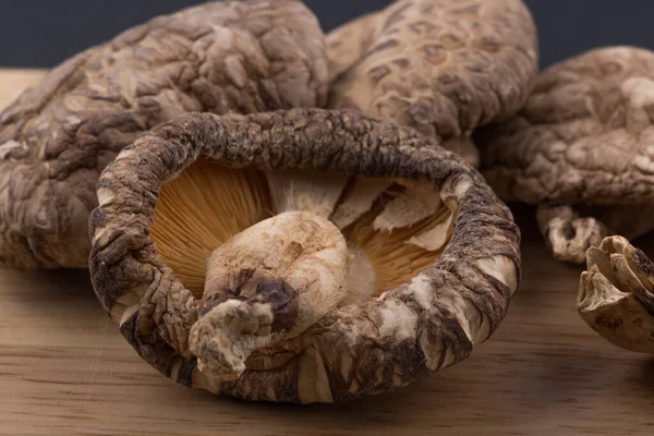 Pile of dried shiitake mushroom isolated on wooden background