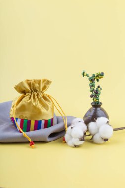 Sarı arka planda çeşitli süslemeleri olan Kore geleneksel hediye çantası..