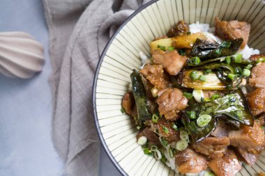 Izgara tavuk butları ve tabakta bir kase pirinç.