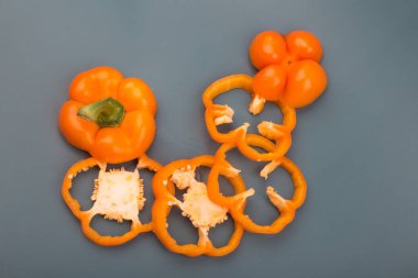 Gri arkaplanda turuncu çan biberi dilimleri izole edilmiş.