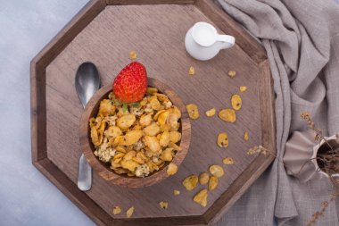 Bir kase mısır gevreği gevreği ve gri arka planda izole edilmiş kaşık.