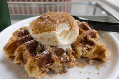 Bir top vanilyalı dondurmayla waffle ızgarasında pişmiş kruvasan hamuru.