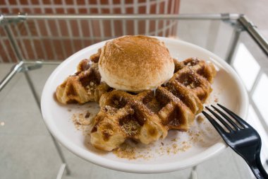 Bir top vanilyalı dondurmayla waffle ızgarasında pişmiş kruvasan hamuru.