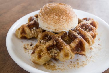 Bir top vanilyalı dondurmayla waffle ızgarasında pişmiş kruvasan hamuru.