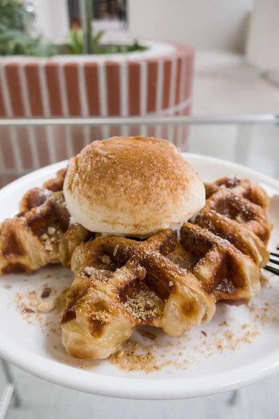 Bir top vanilyalı dondurmayla waffle ızgarasında pişmiş kruvasan hamuru.