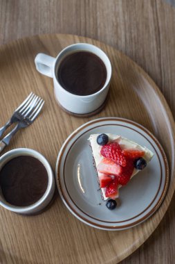 Tahta arka planda beyaz tabakta çikolatalı pasta.