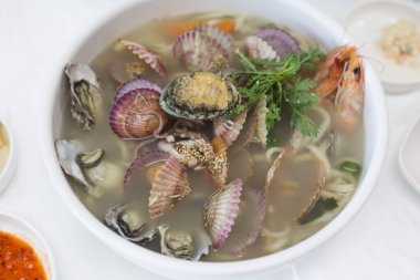 Çeşitli taze deniz ürünleriyle Kore erişte çorbası.