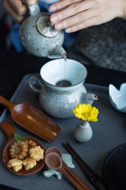 Kadınların elleri bardağa sıcak içecekler döker..