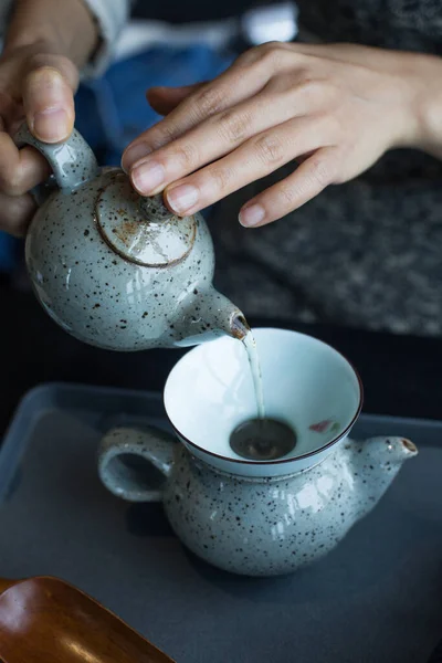 Womens hands pour hot drinks in the cup.