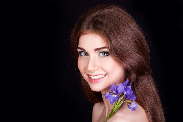 Schöne junge Mädchen mit einer Blume im Haar, Make-up — Stockfoto