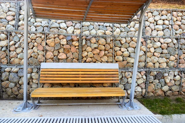 ガビオンの壁に天蓋付きの木製のベンチ 高品質の写真 — ストック写真