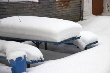 Park masası ve banklar kalın bir kar tabakasıyla kaplı.