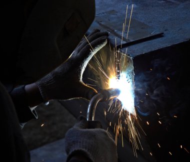 Kaynakçı kıvılcımlarla metal bir yapı oluşturuyor.