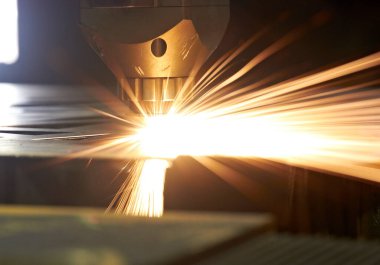 Cnc lazer makinesinin çelik levhalarından lazer kıvılcımları.
