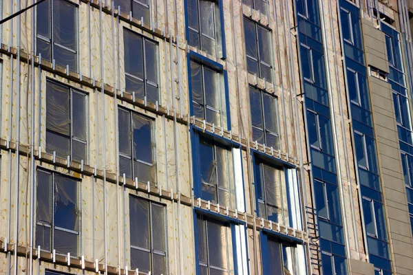 Multistory monolitic concrete apartment building under construction with installed windows — Stock Image Multistory monolitic concrete apartment building under construction with installed windows Stock Photo