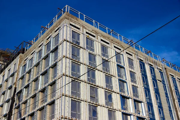 Multistory monolitic concrete apartment building under construction on blue sky background — Stock Image Multistory monolitic concrete apartment building under construction on blue sky background Royalty Free Stock Images