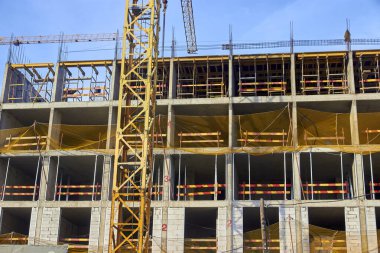 Apartman inşaatında güvenlik ağı ve kule vinci var.