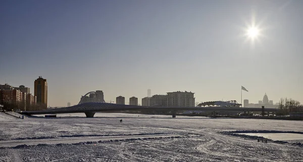 Nur-Sultan, Kazachstan - 03 stycznia 2021: Zimowy widok na miasto w słoneczny dzień nad zamarzniętą rzeką — Zdjęcie stockowe