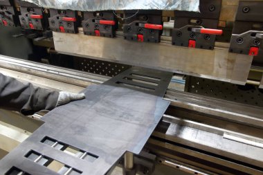 Metal bükme makinesinde çalışan işçilerin çelik bükme işlemi