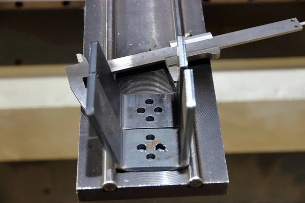 caliper and steel products on the stand of the metal bending machine